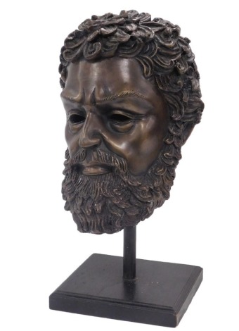 A bronze hollow cast bust of Zeus, raised on a pole and square ebonised base, 43cm high.