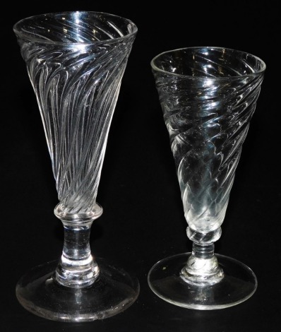 Two 18thC dwarf ale glasses, both with wrythen bowls, one with fringed collar to the base of the slightly fluted bowl, rough pontil mark, 14.7cm, the other short stem, mainly polished pontil, 12.5cm high.