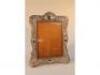 An Edwardian silver repouss? rococo revival picture frame mounted on a wooden frame