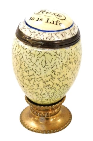 A late 18thC Bilston enamel nutmeg grater, modelled as an egg, the hinged lid decorated with 'As The Rose, So Is Life', grater lacking, 5cm wide.