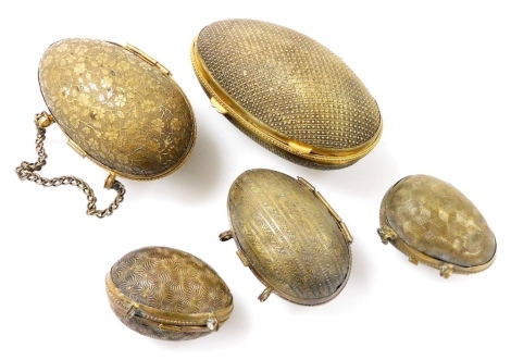 Five Victorian brass thimble holders, modelled as eggs, with engraved decoration, three containing thimbles.