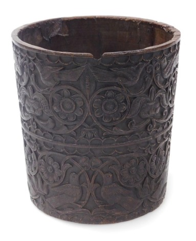 A late 19thC Anglo Indian carved wooden cylindrical bucket, carved with panels of birds and scrolling leaves and flowers, 20cm high.