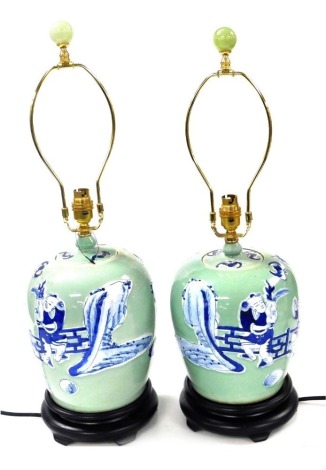 A pair of Chinese blue and white jar and cover table lamps, decorated with figures against a celadon ground, 37cm high. Buyer Note: WARNING! This lot contains untested or unsafe electrical items. It is supplied for scrap or reconditioning only. TRADE ONL