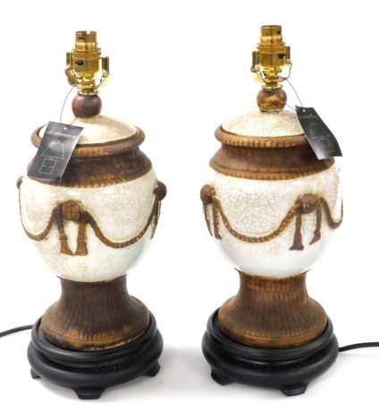 A pair of Chinese crackle glaze cream and buff table lamps, on socle bases, 42cm high. Buyer Note: WARNING! This lot contains untested or unsafe electrical items. It is supplied for scrap or reconditioning only. TRADE ONLY