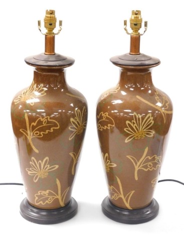 A pair of Chinese brown glazed table lamps, of shouldered tapering form, decorated with flowers and leaves, raised on socle bases, 56cm high. Buyer Note: WARNING! This lot contains untested or unsafe electrical items. It is supplied for scrap or recondit