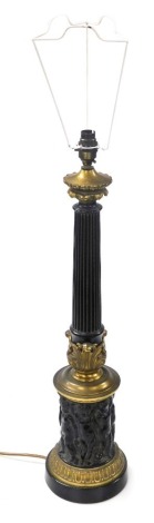 A late 19thC brass and ebonised lamp base, of fluted column form, above a repeating frieze of putti, raised on a socle base, 68cm high.