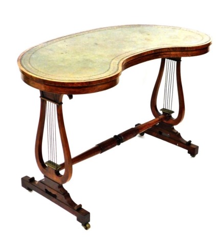 A Regency rosewood kidney shaped centre table, with a tooled green leather top, raised on lyre supports united by a turned stretcher, raised on brass castors, 73cm high, 112cm wide, 56cm deep.