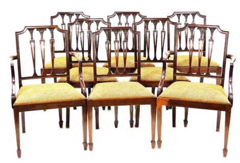 A set of eight Hepplewhite style mahogany dining chairs, early 20thC, with triple foliate and column carved uprights, over drop in seats, raised on tapering square legs on spayed feet, comprising a pair of carvers and six single chairs.