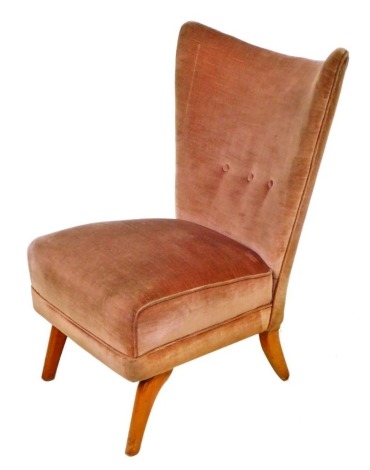 A 1960s beech framed chair, by Howard Keith, upholstered in button back salmon coloured draylon, with overstuffed seat, raised on curved legs, 65cm wide.