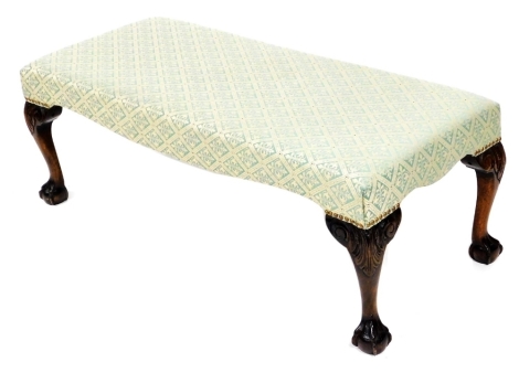 A Georgian style mahogany duet stool, upholstered in green pattern fabric, raised on foliate carved cabriole legs and ball and claw feet, 121cm wide.