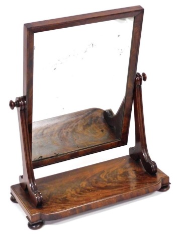 A Victorian flame mahogany swing frame toilet mirror, with a square mirrored plate, over a shaped base, raised on bun feet, 66cm high, 52cm wide.