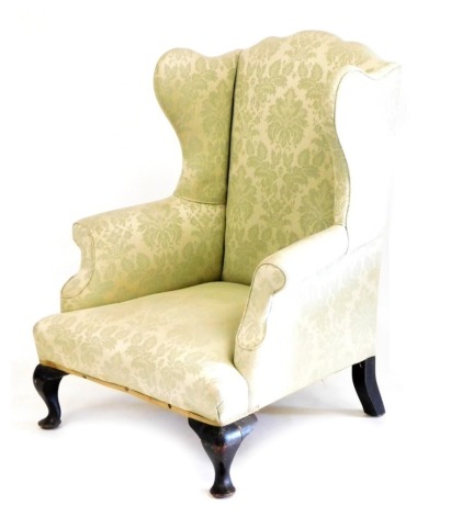 A George III mahogany wingback armchair, upholstered in green pattern fabric, raised on cabriole legs, 84cm wide.