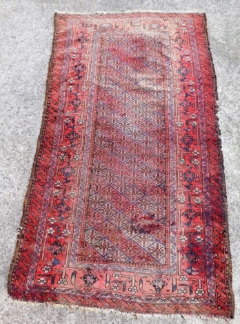 A Caucasian red ground runner, with a central floral geometric rectangular field, within repeating floral borders, 164cm x 93cm.