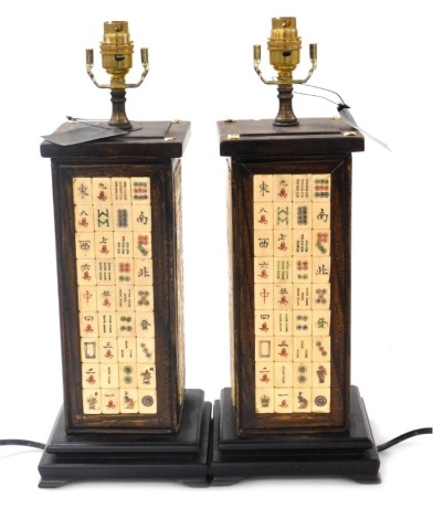 A pair of Chinese hardwood table lamps, of rectangular section, inlaid with panels of mahjong counters, raised on a stepped base above bracket feet, 43cm high. Buyer Note: WARNING! This lot contains untested or unsafe electrical items. It is supplied for