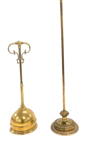 A Victorian brass demi lune doorstop, with scroll handle, 45cm high, together with a brass stand, or doorstop, raised on a circular base, 61.5cm high. (2)