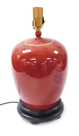 A Chinese Sang-de-boeuf table lamp, raised on a socle base, 48cm high. Buyer Note: WARNING! This lot contains untested or unsafe electrical items. It is supplied for scrap or reconditioning only. TRADE ONLY