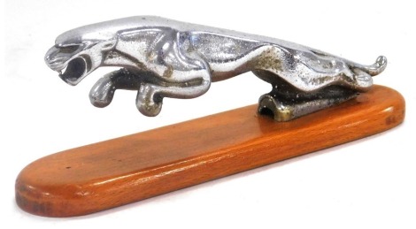 A Jaguar chrome car mascot, raised on an oval wooden base, 19cm wide.