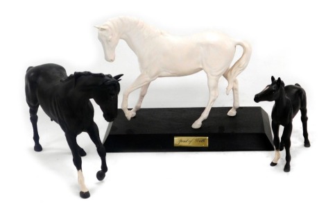 A Beswick matt white figure of Spirit Of Youth, raised on a wooden base, together with a matt black horse, and a foal. (3)