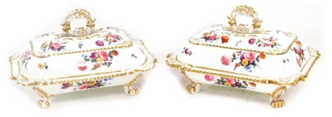 A pair of early 19thC Coalport porcelain vegetable tureens and covers, painted with sprays of flowers, with gilt scroll handles, raised on four paw feet, 28cm wide.