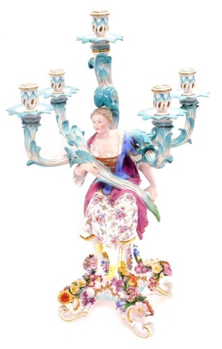 A 19thC Meissen five branch figural and flower encrusted candelabrum, modelled with a seated lady on four floral encrusted scroll feet, blue cross swords mark, 59cm high.