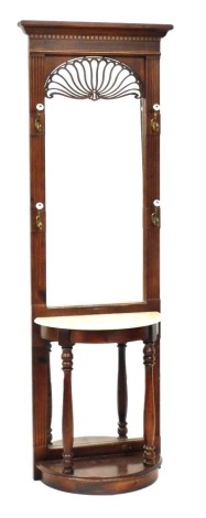 A Victorian style mahogany hall stand, the dentil moulding pediment over an arched glass plate, with fret work fan detailing to the top, above a demi lune base with marble top, raised on turned columns above a plinth base, backed by mirrored glass, 203cm 