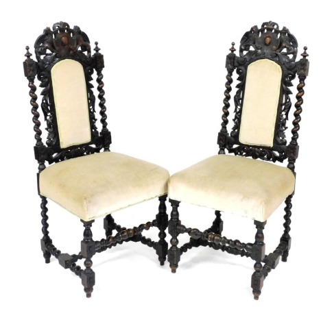 A pair of 19thC Carolean style carved oak dining chairs, the crest rail carved with griffins, raised on barley twist supports, with foliate carved and overstuffed back, over an overstuffed seat, raised on barley twist and turned legs, united by turned str