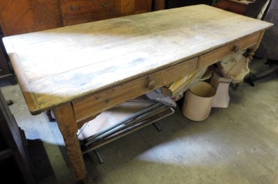 A 19thC pine dairy table, with a planked top above two frieze drawers to one side, on spirally turned legs, 81cm high, 210cm wide, 86cm deep. (AF)