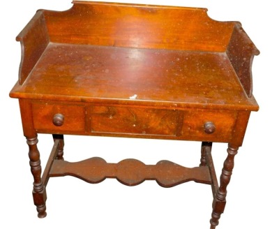 A Victorian mahogany washstand, with a raised gallery above two frieze drawers and a false drawer, on turned legs with shaped under tier.