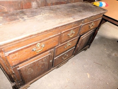 An early 19thC oak and mahogany cross banded dresser, the base with an arrangement of five drawers and two doors, with raised panels, flanked by rounded pilasters, on ogee bracket feet, with an associated plate rack, the base 89cm high, 152cm wide, 44cm d - 2