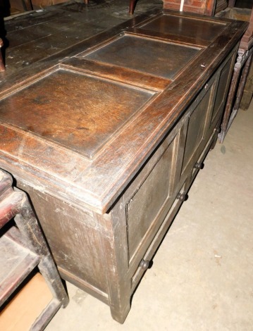 A late 17th/early 18thC oak mule chest, with a planked top above three panels and two drawers, on stiles with castors, 83cm high, 131cm wide, 54cm deep.