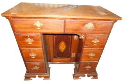 A 19thC mahogany ebony strung kneehole dressing table, the plain rectangular above eight drawers around a central shell inlaid panelled door, on ogee bracket feet, 94cm high, 107cm wide, 52cm deep.