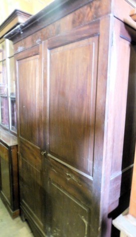 A 19thC mahogany wardrobe or armoire, with moulded cornice above two panelled doors, above a shaped apron and bracket feet, 115cm high, approx 148cm wide.