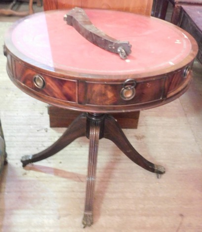 A mahogany drum top library table in Regency style, the circular top with a red and gilt leather insert, above an arrangement of drawers and false drawers, on a turned column and reeded splayed legs, 77cm diameter. (AF)