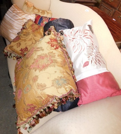 A collection of embroidered and other cushions.