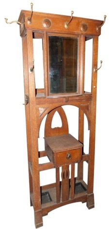 An early 20thC oak hall stand in the manner of Liberty, with hammered copper panels, the top with a bevelled mirror plate, flanked by various shaped brass hooks, the base with a single drawer and two recesses for umbrellas, walking sticks, etc., on block 