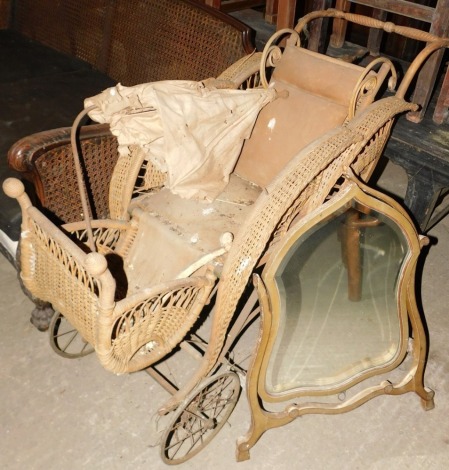 A Victorian basket work or rattan child's pram or pushchair, with solid spoked wheels and turned wooden handle, and a cream painted shield shape dressing table mirror (2, AF).