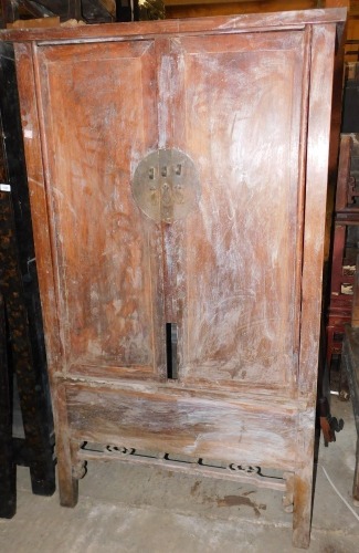 A late 19thC Chinese elm cabinet, the two doors with brass mount enclosing a recess and two drawers above a shaped apron on plain legs, 187cm high, 107cm wide, 51cm deep.