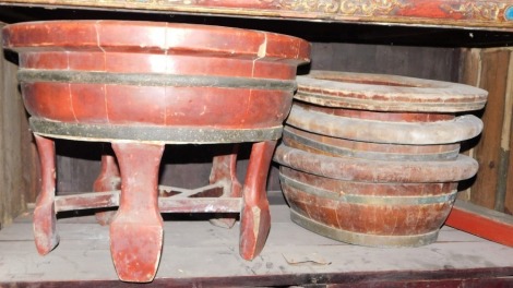 A Chinese oval wash bowl, with coopered bands on tapering stand with under tier, 50cm wide, and three others, lacking stands.