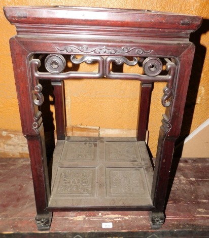 A Chinese hardwood two tier occasional or urn table, with a square top with a raised border, above a carved and pierced frieze on shaped legs, 77cm high, 48cm wide.