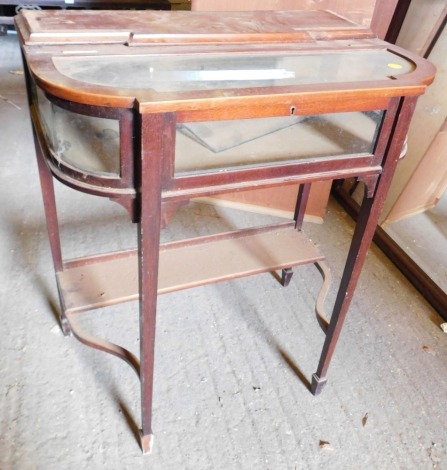 An Edwardian mahogany display table, with a hinged glazed lid, glazed sides on square tapering legs with under tier, 77cm high, 67cm wide.