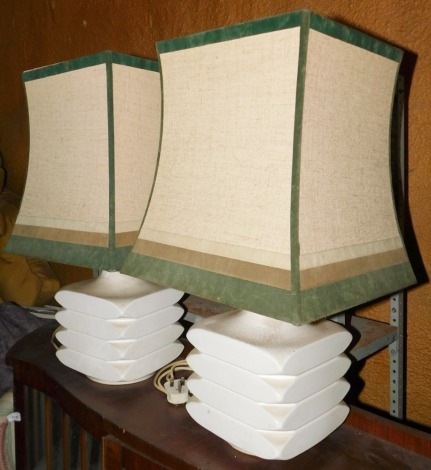 A pair of cream glazed table lamps, each with a coloured shade, 67cm high.