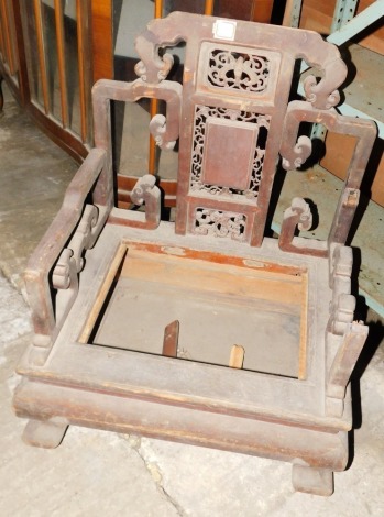 A carved Chinese throne or low chair, with a panelled and pierced back, shaped arms and legs (AF), 54cm wide.