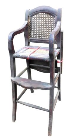 A late 19th/early 20thC high chair, with a caned back, a rattan woven seat, on splayed legs with turned stretchers.