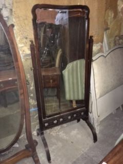 A late 19th/early 20thC mahogany cheval mirror, the rectangular plate with shaped top, on reeded supports with fret work stretcher, on down swept legs with castors, 171cm high, 76cm wide.