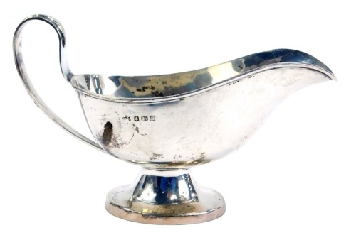 A George V silver sauce boat, of plain design with stylised rat tail handle, and raised on a tapered oval foot, Birmingham 1915, 2.68oz.