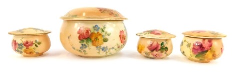 A group of four Royal Worcester blush porcelain dressing table and ointment jars and covers, painted with flowers, printed marks.