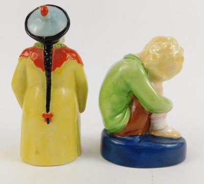 A Royal Worcester porcelain candle snuffer, circa 1923, modelled as a china man, standing holding a fan, printed marks, and a Royal Worcester figure modelled by Margaret Cane as Sleepy Boy, number 2918. (2, AF) - 2