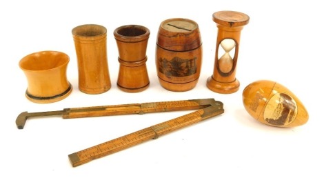 A group of treen, comprising a Leamington Spa egg cup, a treen dice shaker, egg timer, Forth Bridge Switzerland money bank barrel, folding rule, egg cup, etc. (7)