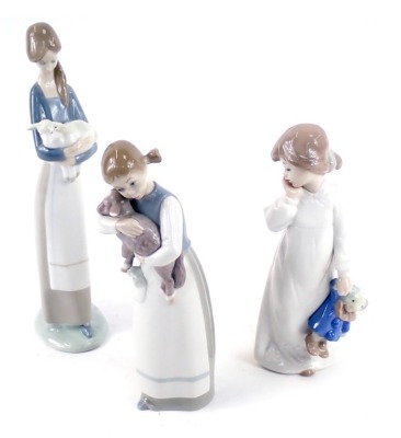 Two Lladro figures, comprising a girl carrying lamb, child carrying lamb, and a Nao child with clown teddy bear. (3) Auctioneer Announce: two Lladro figures in lot and one Nao