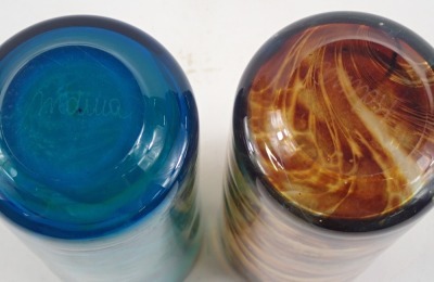 Two Mdina art glass cylindrical vases, one with blue and green swirl decoration, the other with orange and brown, 20cm high, signed. (2) - 2